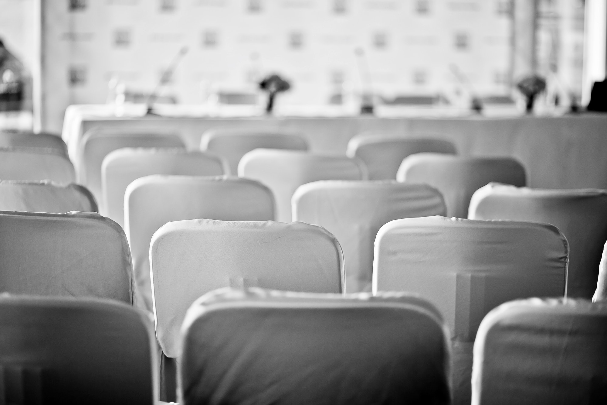 Press conference. Black and white. Chairs. Conference. Official event.